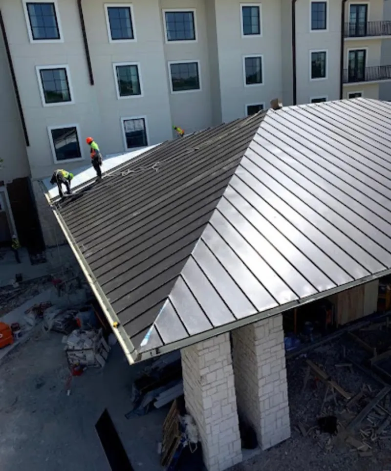 Crew installing standing seam metal roof panels on a commercial project in Lady Lake